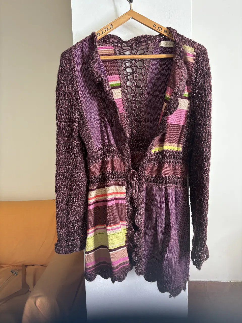 Cardigan tejido a mano en tonos morados y detalles multicolores. Ideal para un look bohemio y artesanal. Perfecto para usar en otoño o invierno.