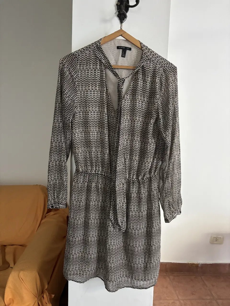 Vestido midi de mujer, con estampado abstracto en blanco y negro. Tiene mangas largas, cintura entallada con lazo y cuello en V. Ideal para un look elegante y versátil.