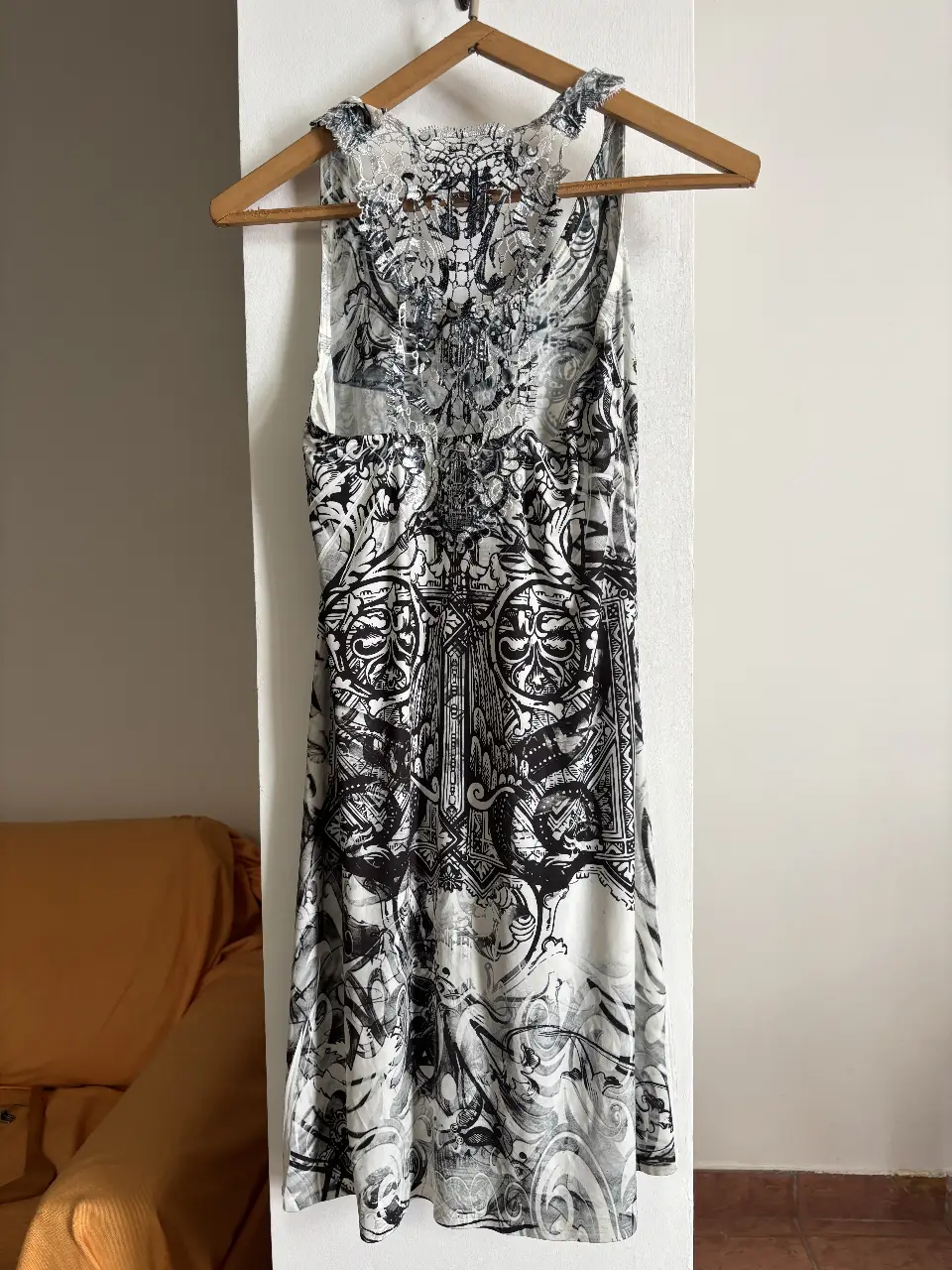 Vestido de mujer con estampado en blanco y negro. Diseño con detalles ornamentales y espalda descubierta. Ideal para salidas y eventos.