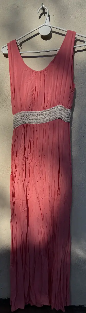 Vestido largo de color rosa, con detalle de cinturón en la cintura. Ideal para eventos especiales o salidas casuales.