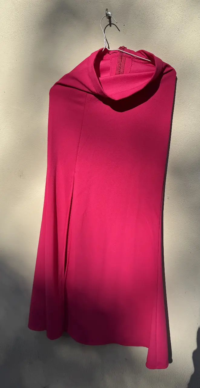 Pollera larga fucsia con cuello alto y cierre al costado. Ideal para eventos formales o salidas nocturnas.