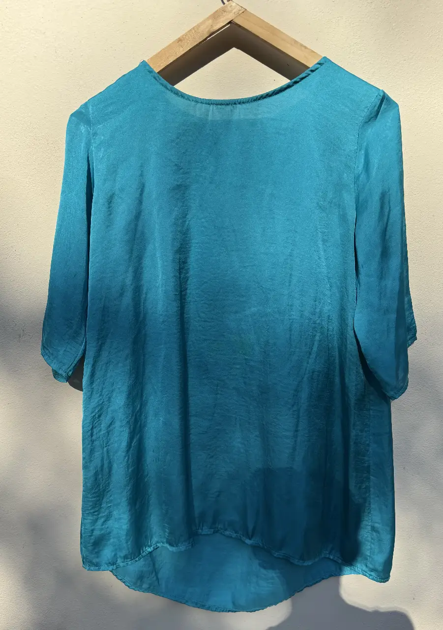 Blusa de seda turquesa, con mangas 3/4 y corte holgado. Ideal para un look elegante y fresco.