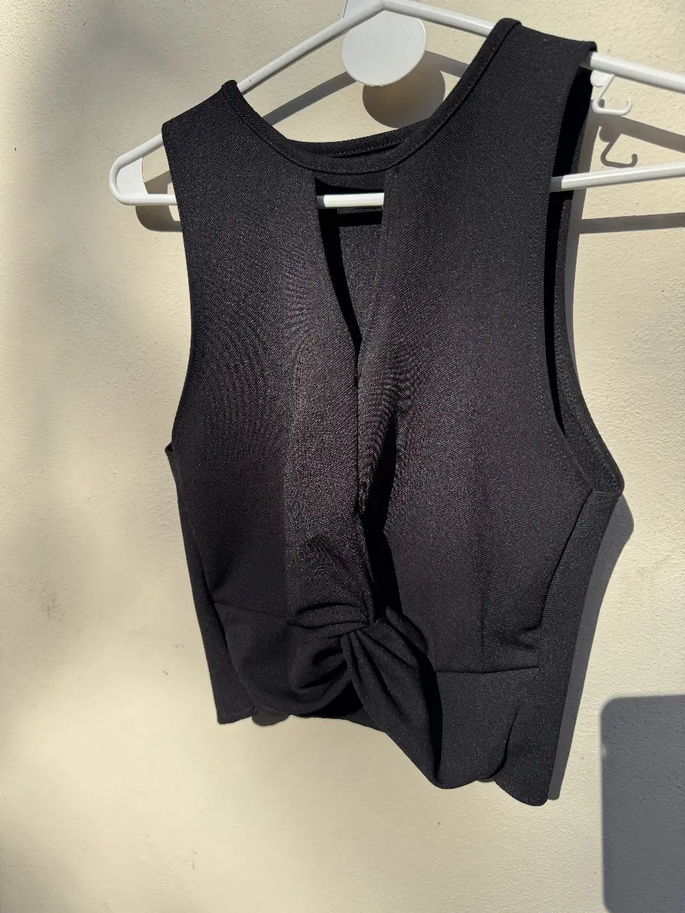Top  negro con detalle de nudo en el frente y escote pronunciado. Ideal para eventos, noche o looks casuales.