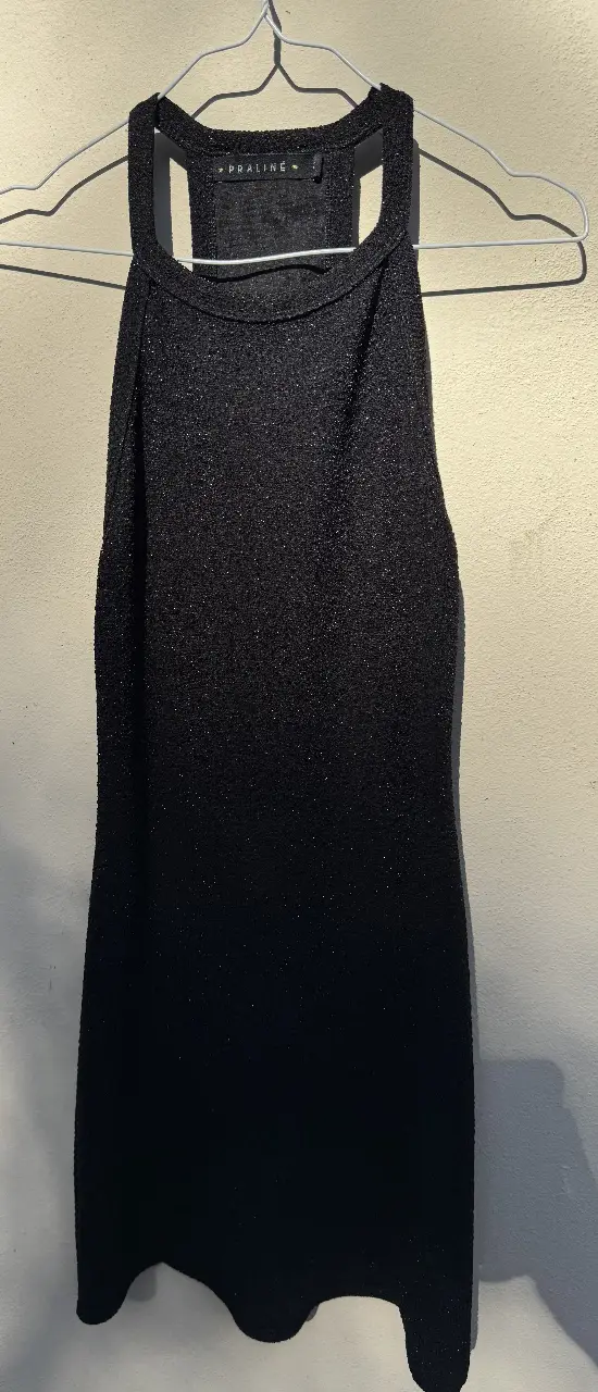 Vestido negro ajustado con brillo, ideal para fiesta o salida. Diseño elegante y moderno.