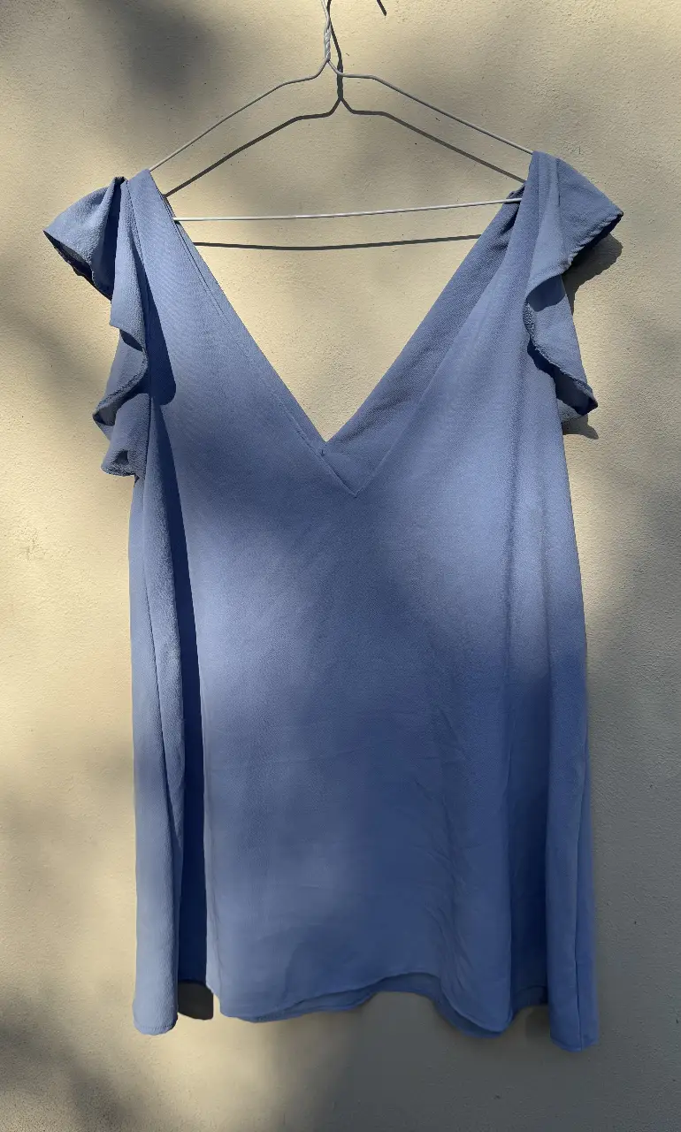 Vestido celeste con escote en V y volados en las mangas. Ideal para un look fresco y femenino.