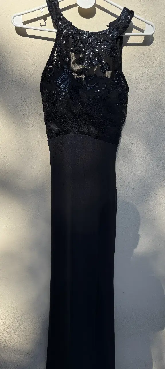 Vestido largo de fiesta negro con detalles de encaje en la parte superior. Ideal para eventos formales y ocasiones especiales.