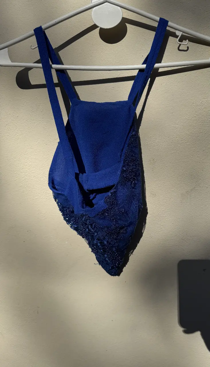 Top azul con detalles de encaje y pedrería. Ideal para eventos especiales o para darle un toque elegante a tu look.
