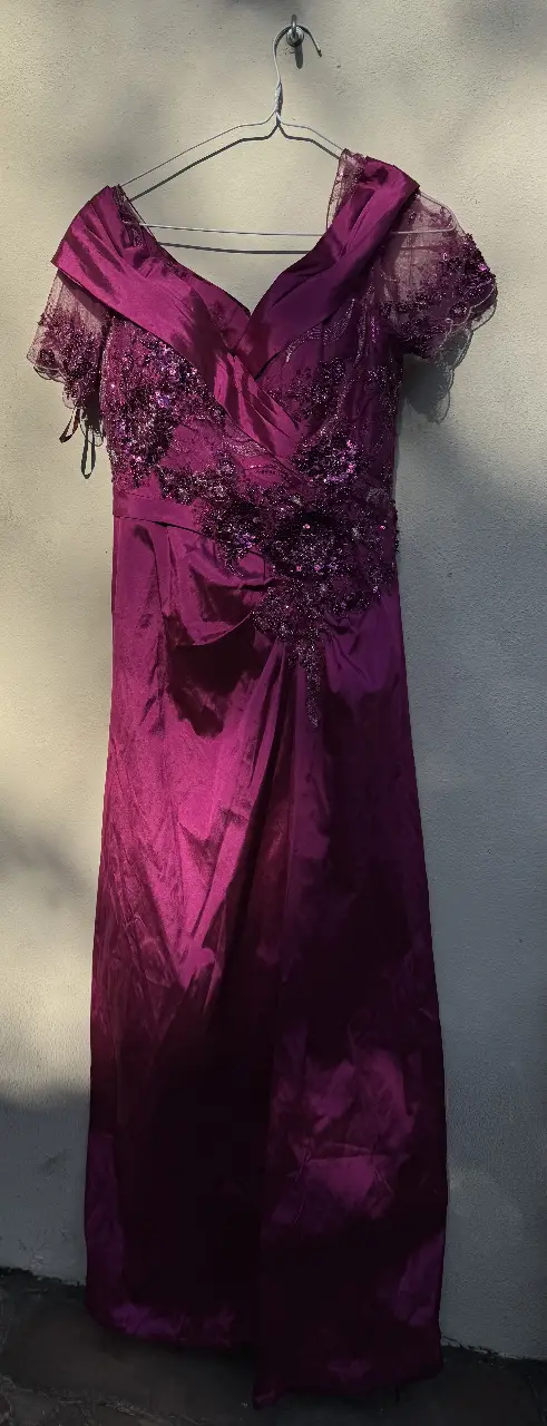 Vestido de fiesta largo en tono violeta, con detalles de encaje y pedrería en la parte superior. Ideal para eventos especiales.