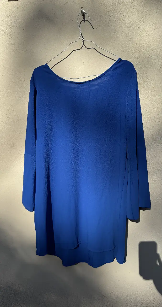 Vestido azul con espalda descubierta y mangas 3/4. Ideal para un look elegante y moderno.