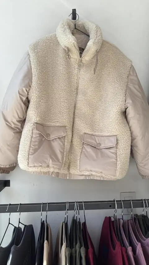 Campera de abrigo con diseño en dos texturas, con cuerpo de tejido tipo borrego y mangas en material liso. Posee dos bolsillos delanteros con solapa y cierre frontal con cremallera.
