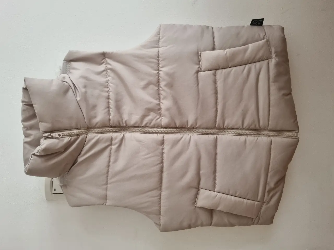 Chaleco puffer negro, vison, y nude sin capucha unisex. Ideal para el invierno, este chaleco acolchado ofrece abrigo y estilo. Cuenta con cierre y bolsillos laterales.