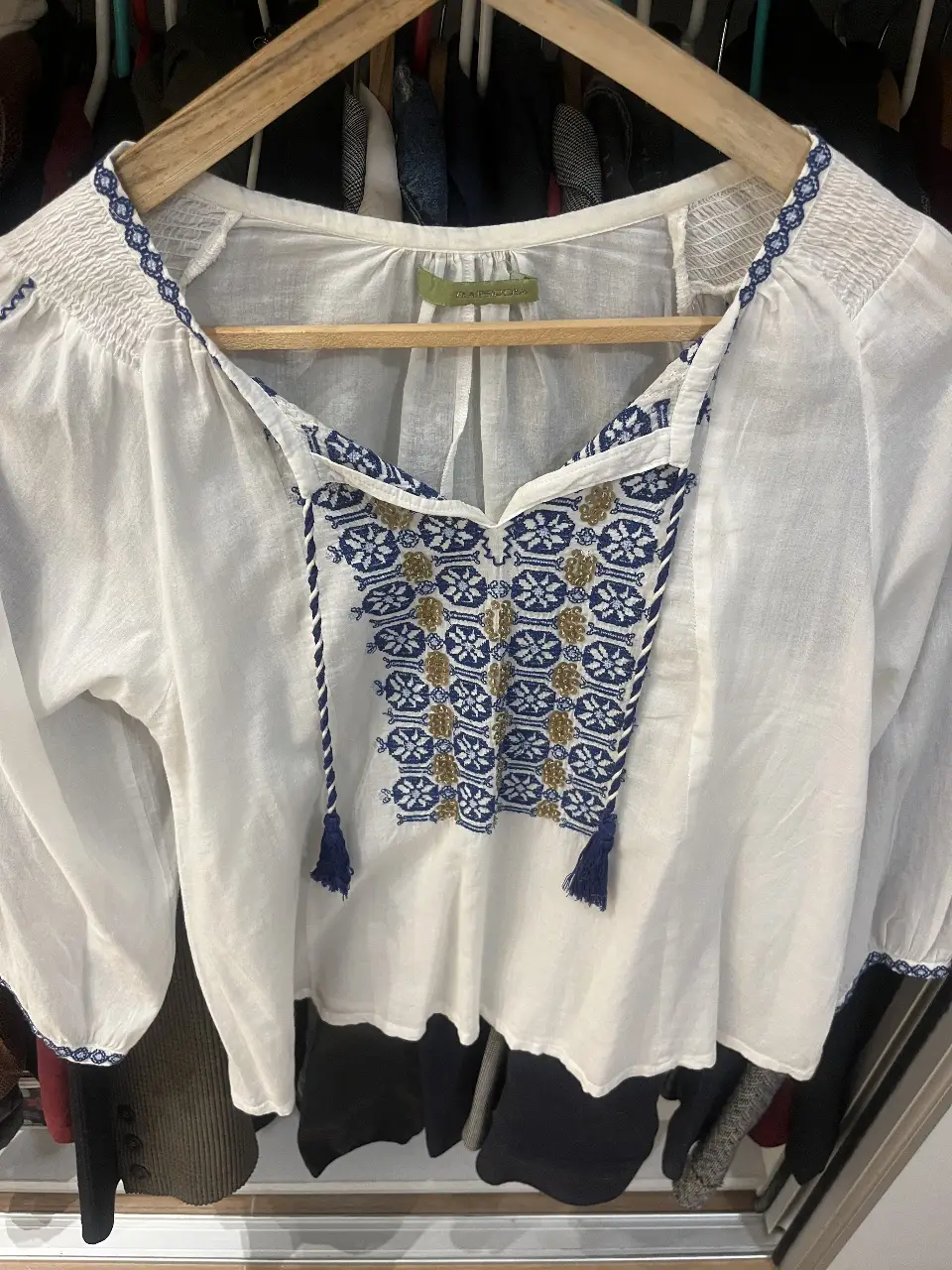 Blusa blanca con detalles bordados en azul y dorado. Estilo boho, ideal para un look casual y fresco.