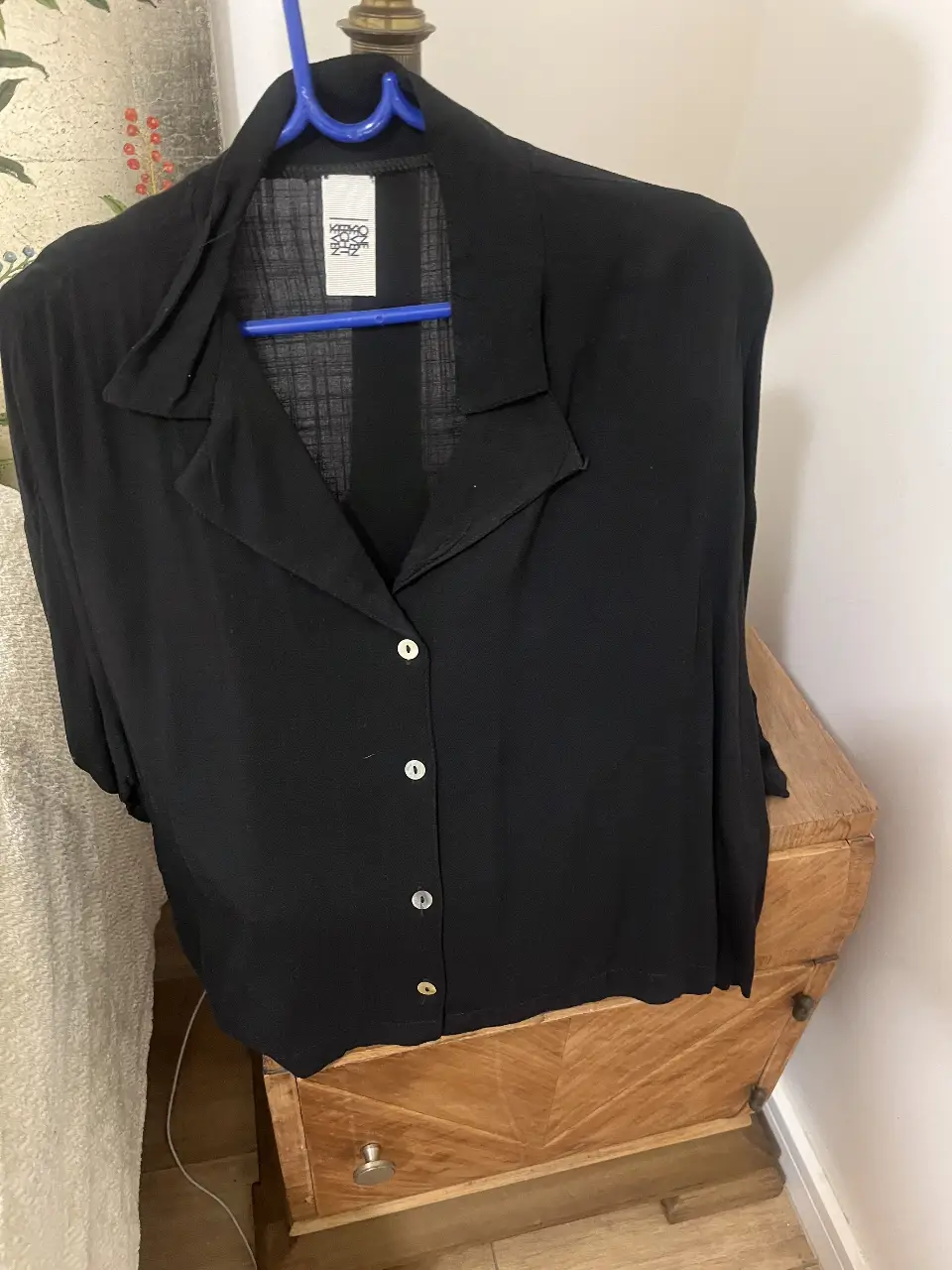 Camisa negra de manga larga con botones y cuello. Ideal para un look elegante y versátil.