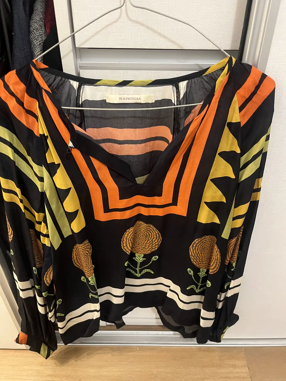 Blusa estampada de la marca Rapsodia, con diseño geométrico y floral. Manga larga y escote en V. Ideal para un look bohemio y con estilo.
