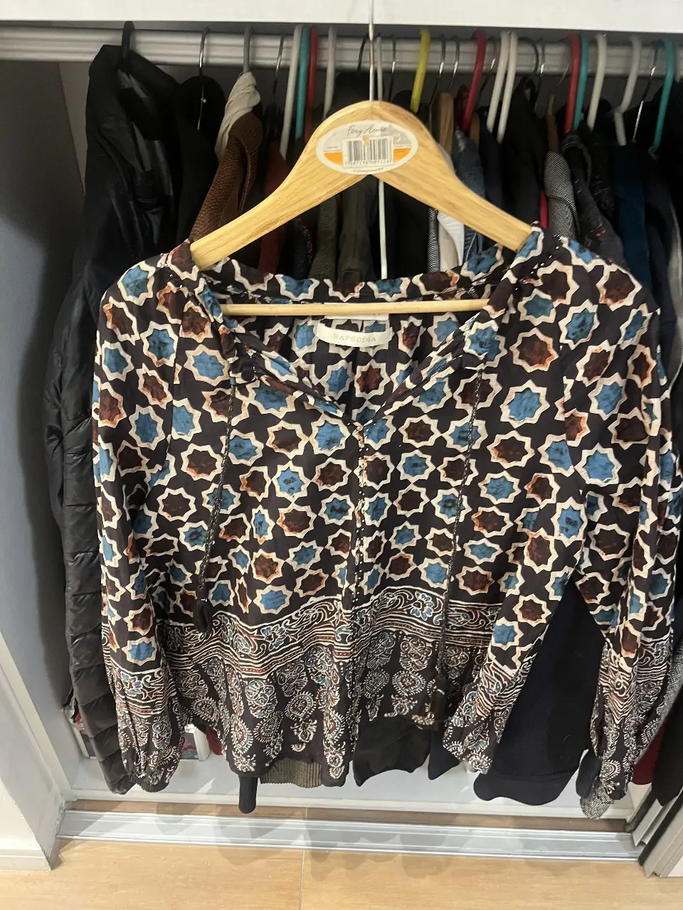 Blusa estampada de manga larga con diseño geométrico en tonos azules y marrones. Ideal para un look bohemio y casual.
