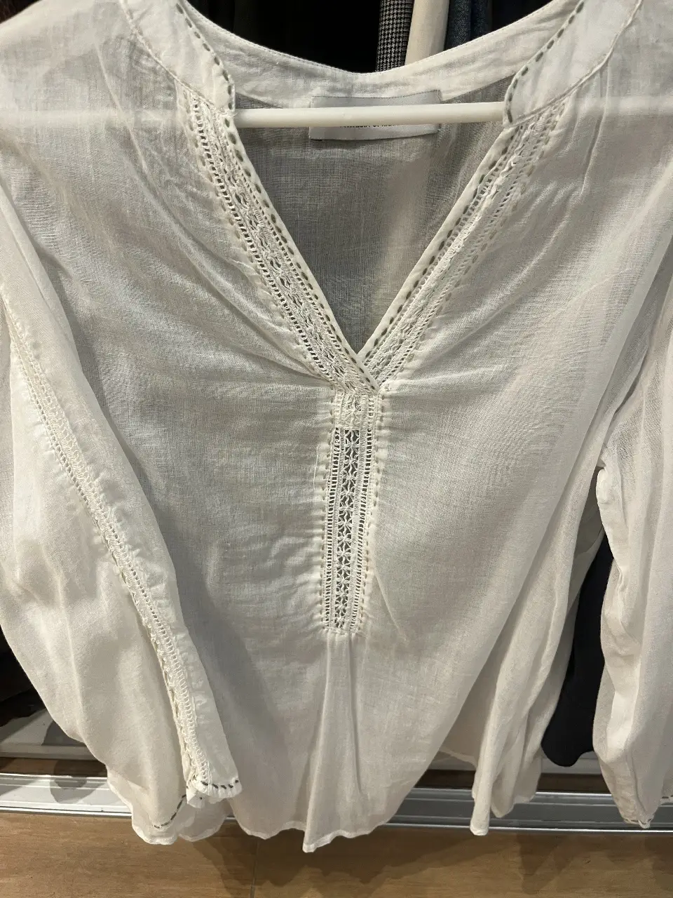 Blusa blanca de lino con detalles de bordado en el cuello, en laterales de las mangas y en la parte delantera. Ideal para un look fresco y elegante.