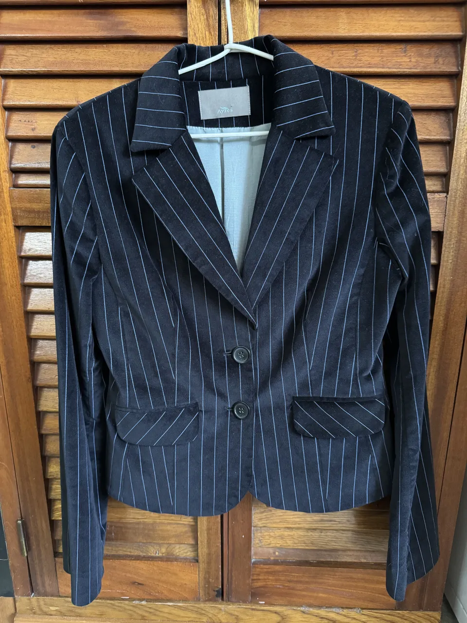 Conjunto de blazer y pantalón a rayas, ideal para un look formal o de trabajo. El blazer es entallado y tiene dos botones al frente, mientras que el pantalón es recto y también a rayas. El tejido es suave y con un ligero brillo.