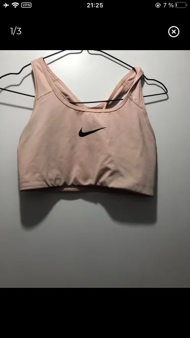 Top deportivo Nike color rosa, ideal para entrenamientos. Con logo de la marca en el frente y espalda cruzada.