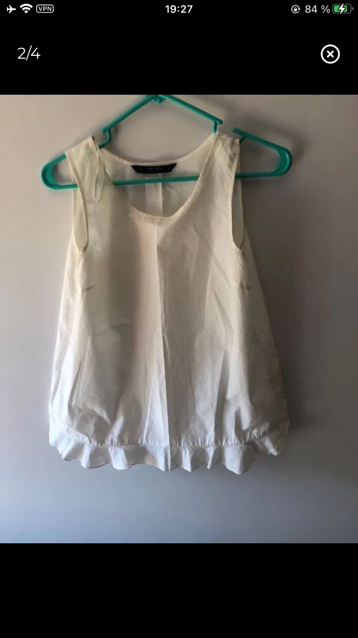 Blusa sin mangas de color blanco, con detalle de volados en el bajo. Ideal para un look fresco y casual.
