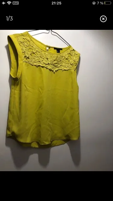 Blusa amarilla con detalle de encaje en el cuello. Ideal para un look fresco y femenino.
