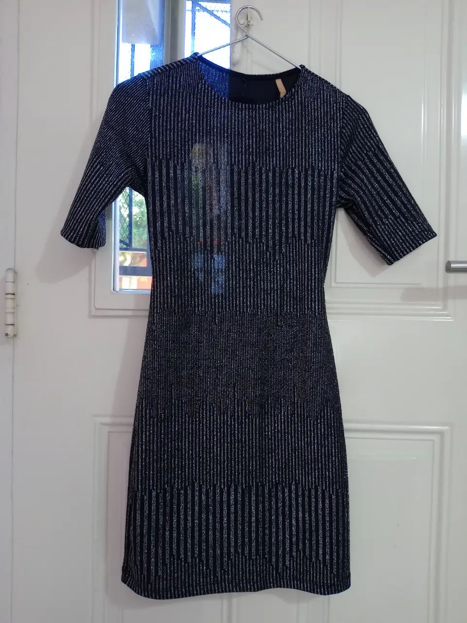 Vestido midi de fiesta con diseño de rayas verticales en color azul y detalles plateados. Corte ajustado y espalda descubierta. Ideal para eventos especiales.
