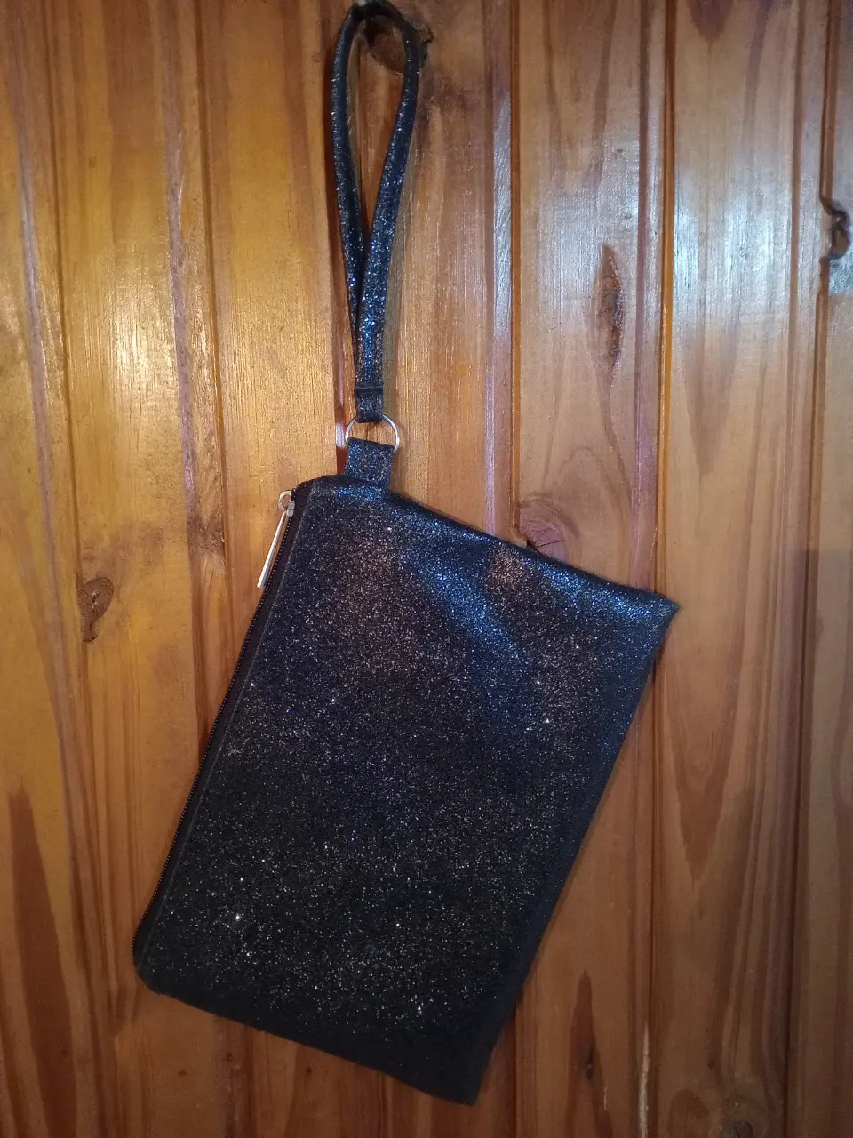 Clutch negro con brillos, ideal para fiestas y eventos especiales. Diseño elegante y moderno.