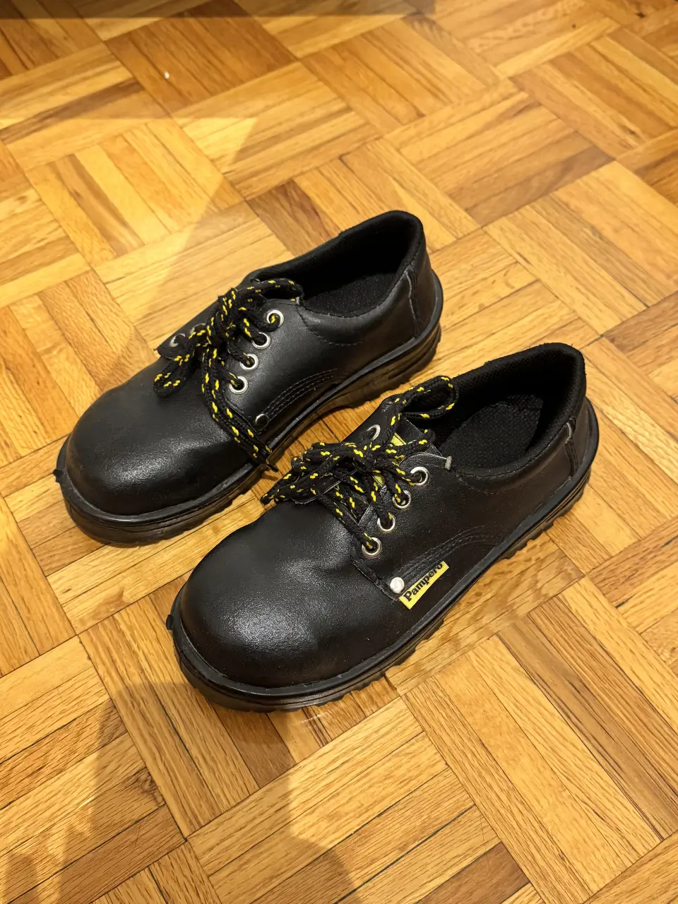 Borcegos de seguridad Pampero, color negro, con cordones amarillos y negros. Ideales para trabajo.