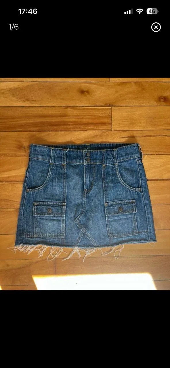 Pollera de jean azul LEVI’S con detalles de desgaste en el ruedo. Posee bolsillos delanteros y traseros con tapa y botón.