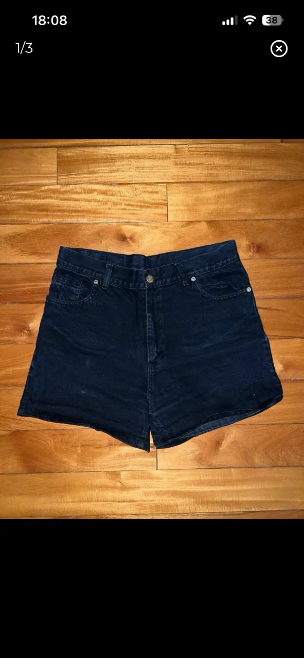 Shorts de jean negro. Modelo clásico con cinco bolsillos y cierre. Tiro alto