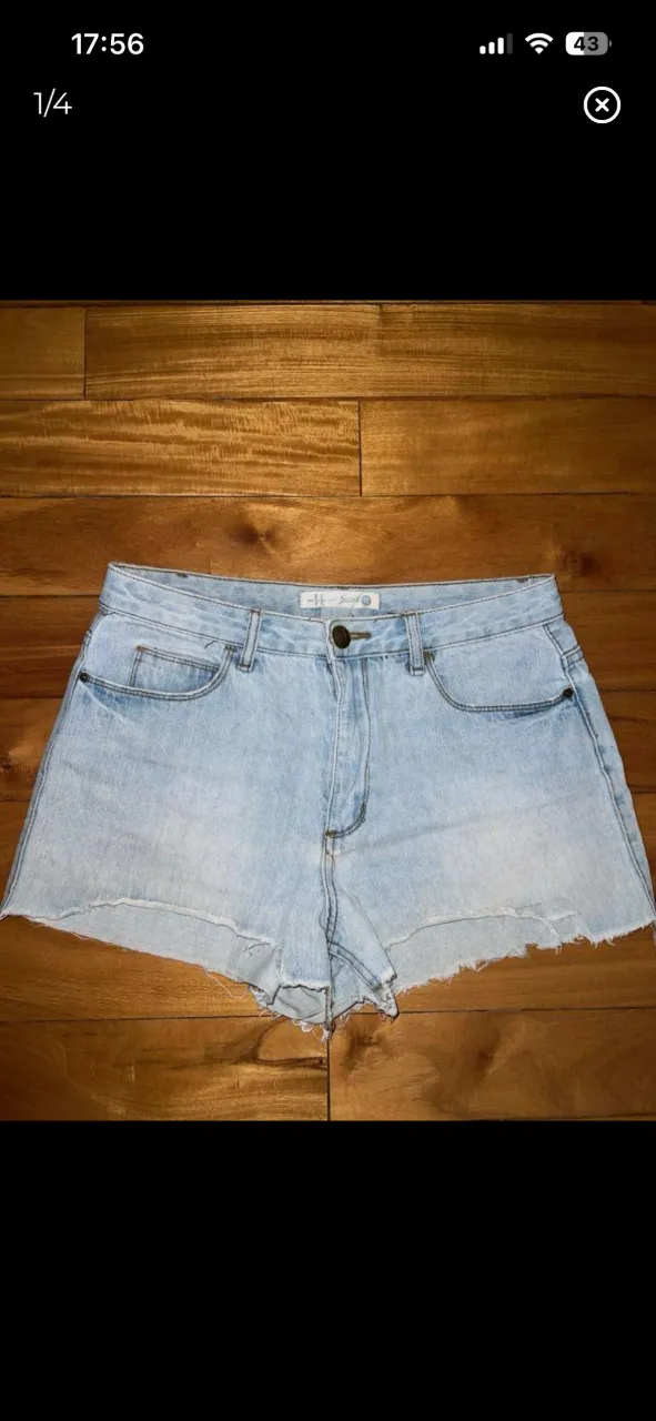 Shorts de jean tiro medio, color celeste claro, con roturas y terminación deshilachada en los bordes.