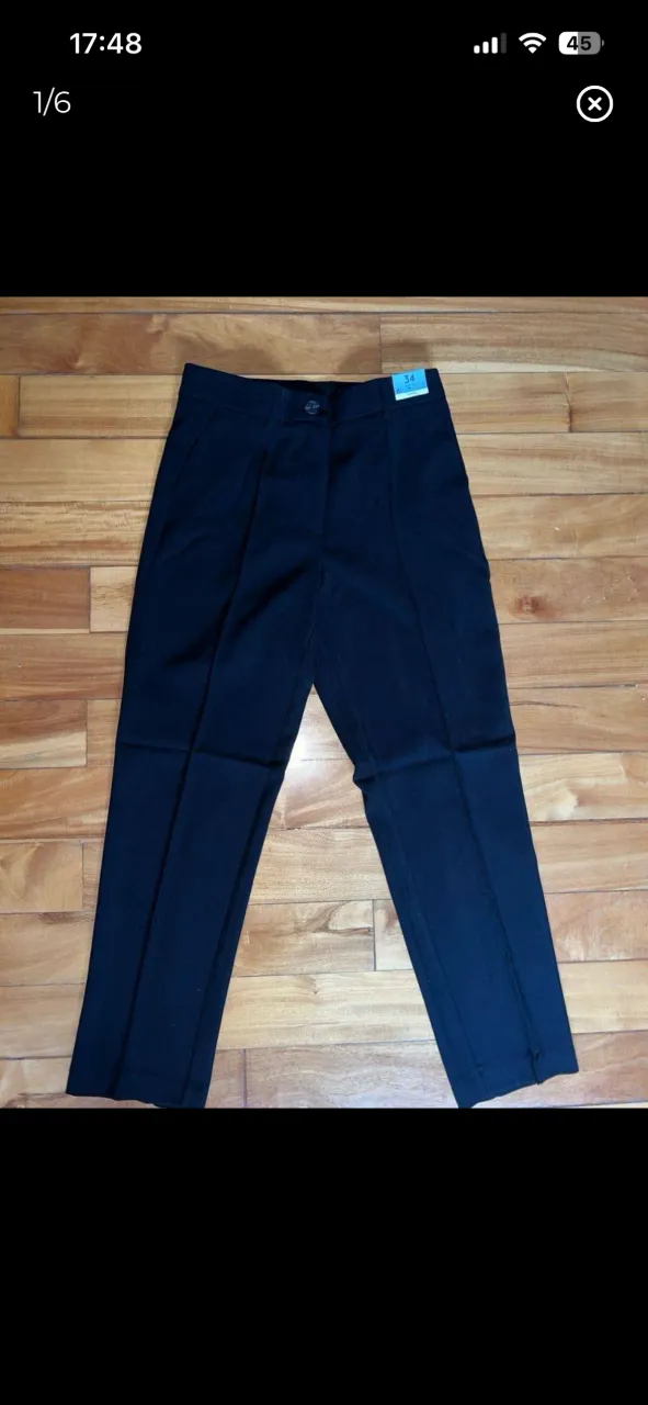 Pantalón de vestir negro con pinzas delanteras y un bolsillo trasero. Cierre con botón y cierre. Marca Lefties