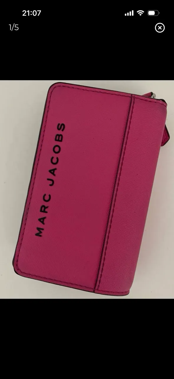 Billetera color fucsia con cierre y logo de la marca en negro. Interior negro con múltiples compartimentos para tarjetas y billetes. Revisar publicación, tiene detalles.