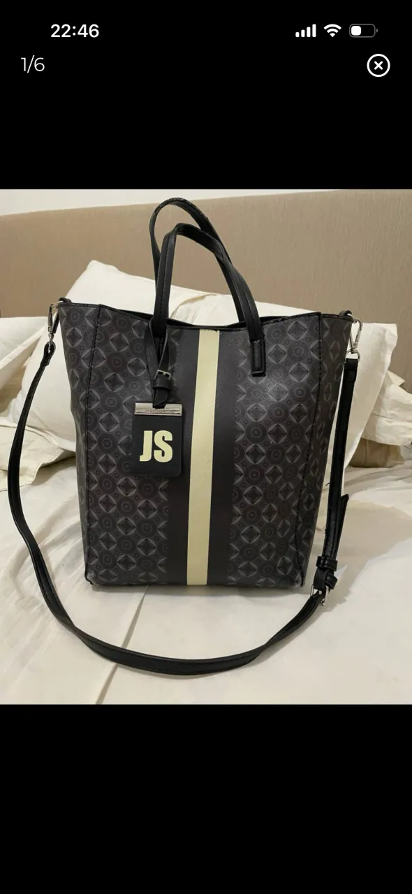 Bolso negro con estampa geométrica en gris y una franja horizontal blanca. Tiene dos asas cortas y una correa larga desmontable. Ver detalle de uso en las fotos. 