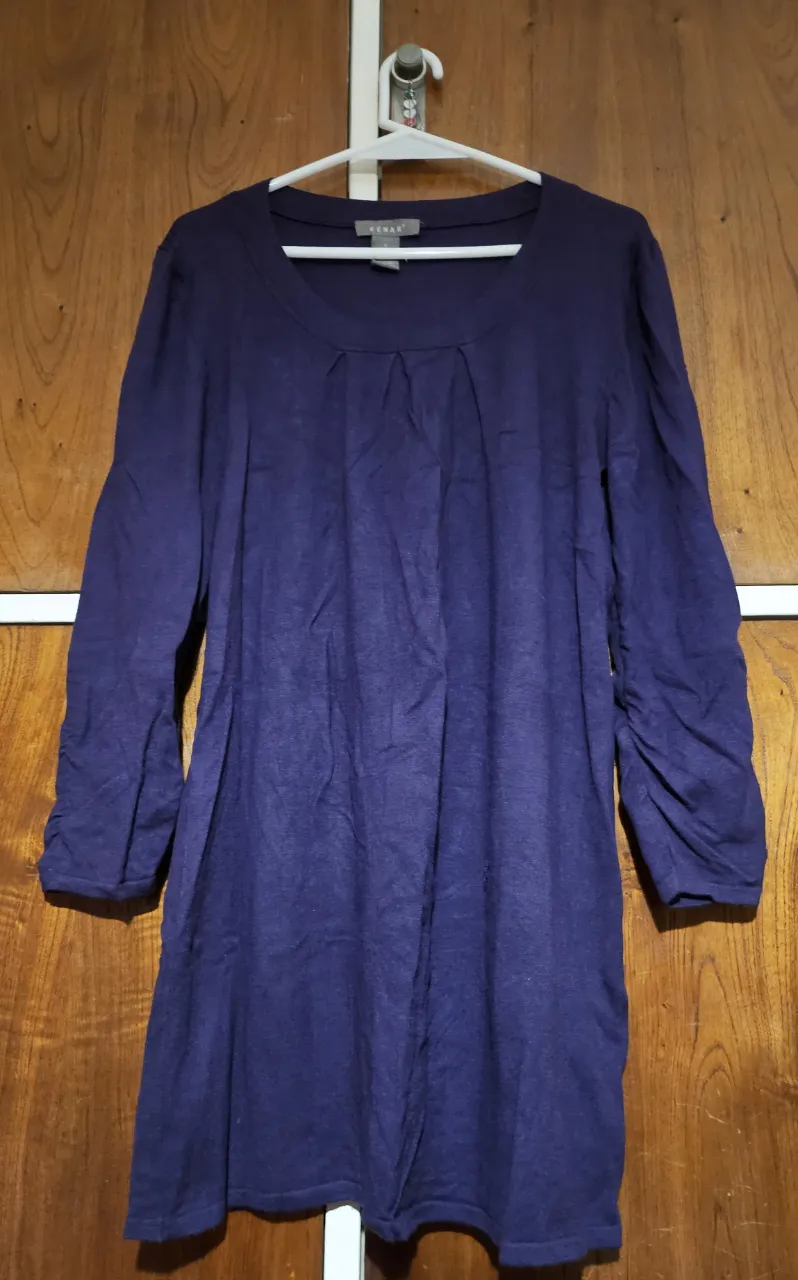 Vestido midi de color azul oscuro, con mangas 3/4 fruncidas en los puños. Tiene un diseño con frunces en la parte delantera y un corte que favorece la figura. Ideal para un look elegante y cómodo.