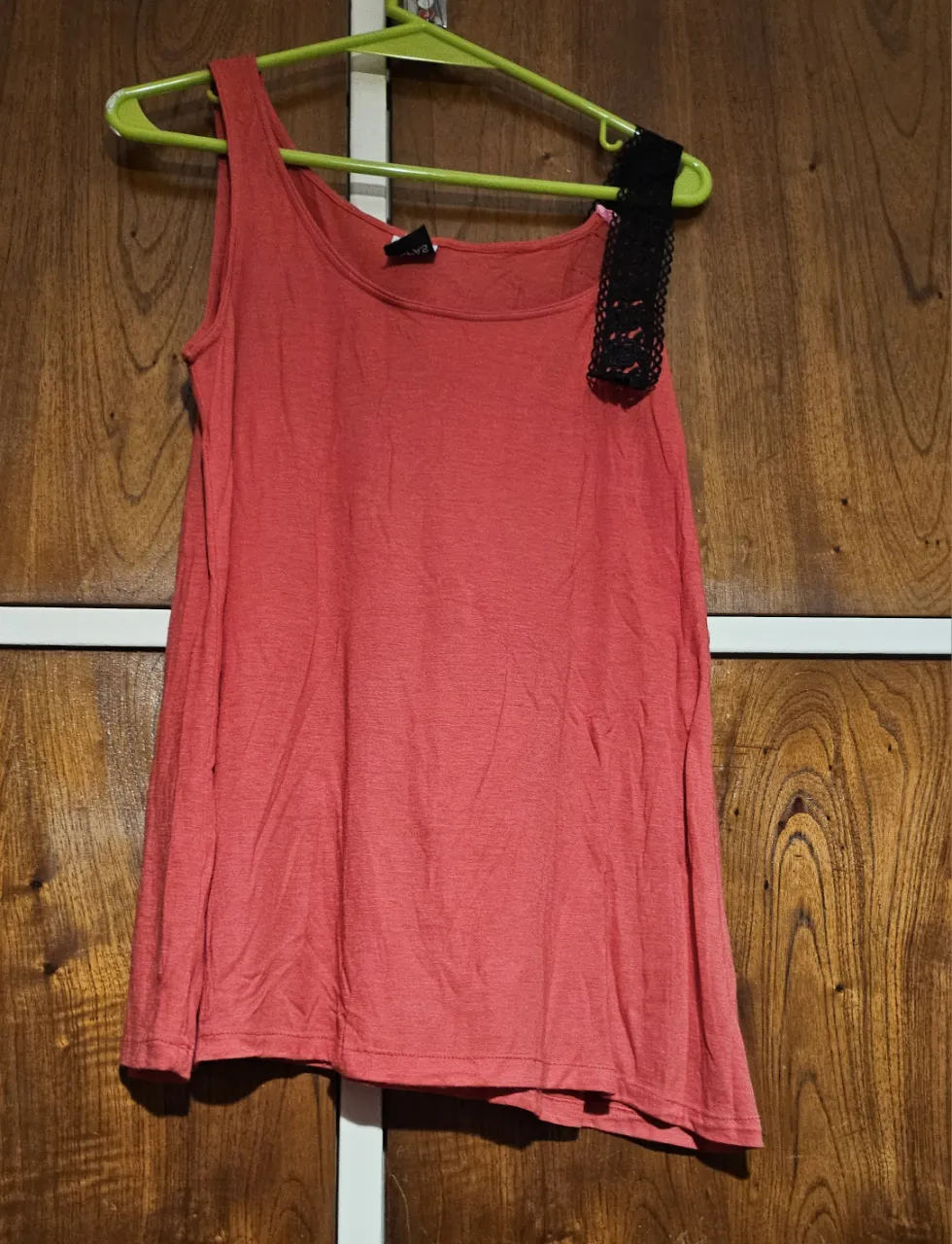 Musculosa roja con detalle de encaje negro en el hombro. Ideal para un look casual y fresco.
