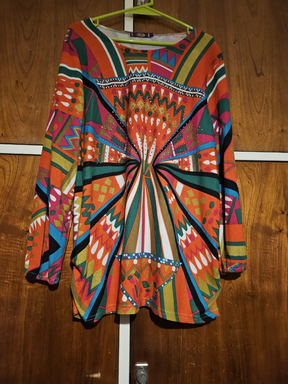 Remera de manga larga con estampado geométrico vibrante. Ideal para un look retro y llamativo. Perfecta para combinar con jeans o pantalones de tiro alto.