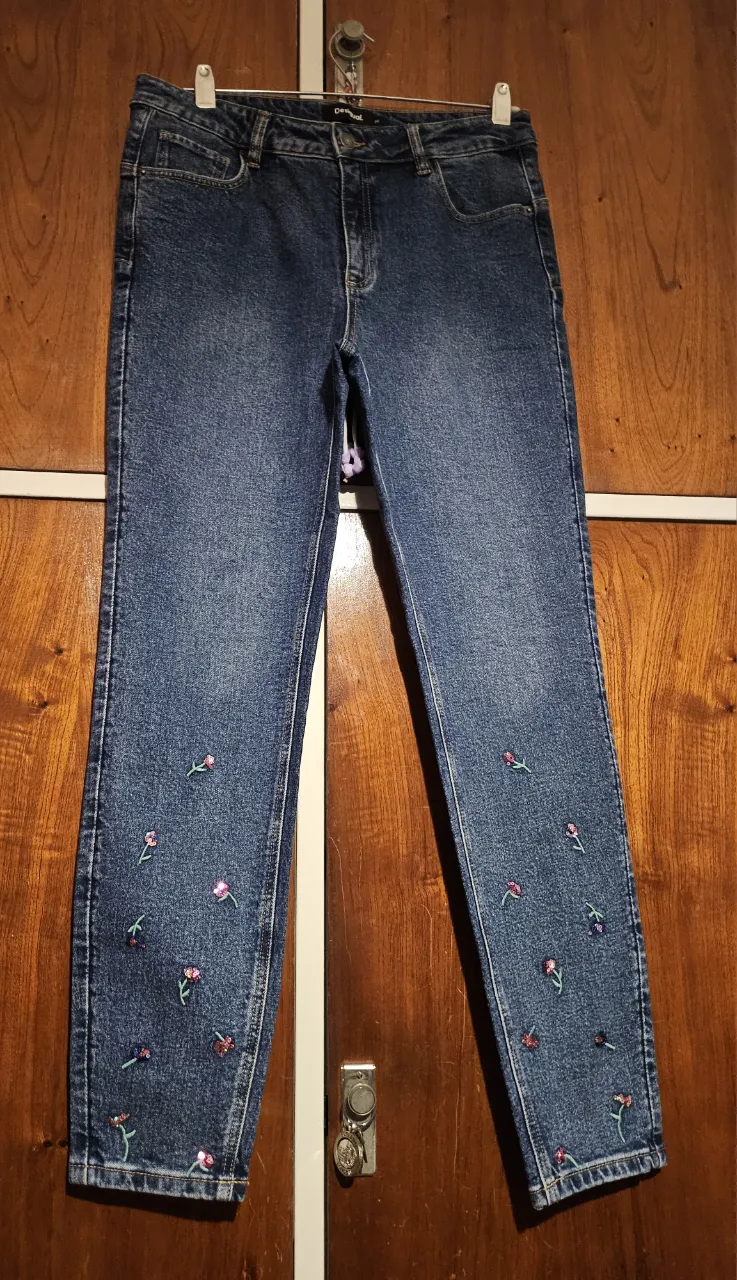 Jeans de mujer, corte recto, con detalles de flores bordadas en los bajos. Un clásico renovado para un look casual y con onda.