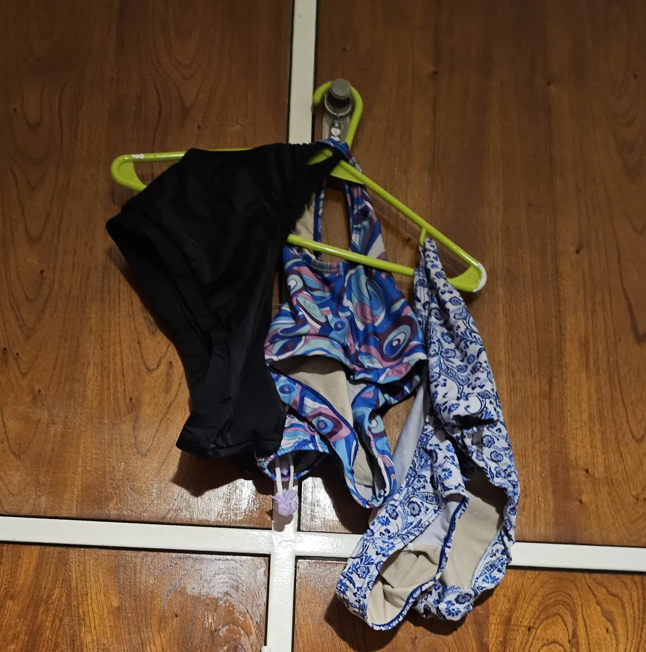 Conjunto de trajes de baño para mujer, incluye una parte de abajo negra y dos partes de arriba con diseños coloridos.