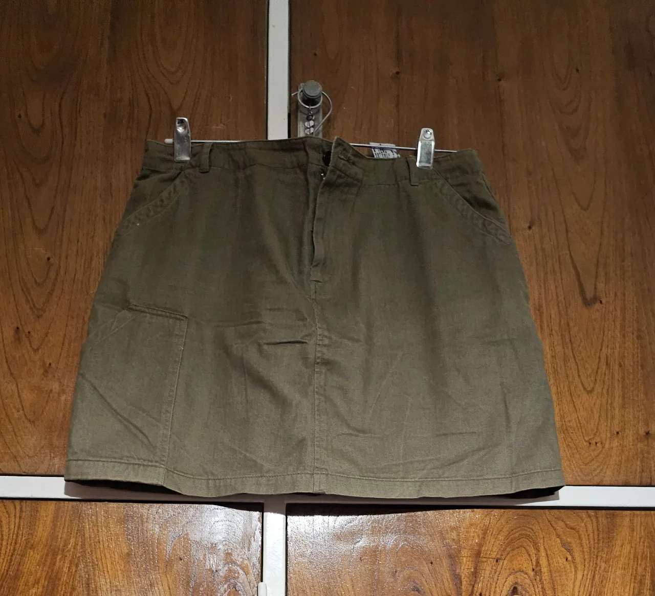 Pollera de gabardina verde militar con bolsillos delanteros y cierre. Ideal para un look casual y canchero.