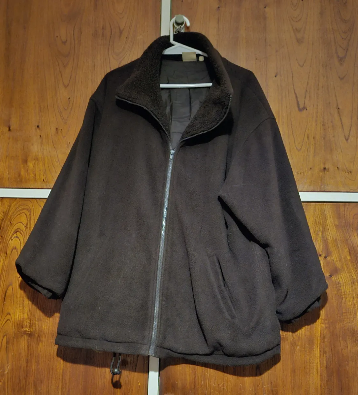 Campera de abrigo marrón oscuro, con cierre frontal y cuello alto con forro de piel sintética. Ideal para el invierno, cómoda y abrigada.