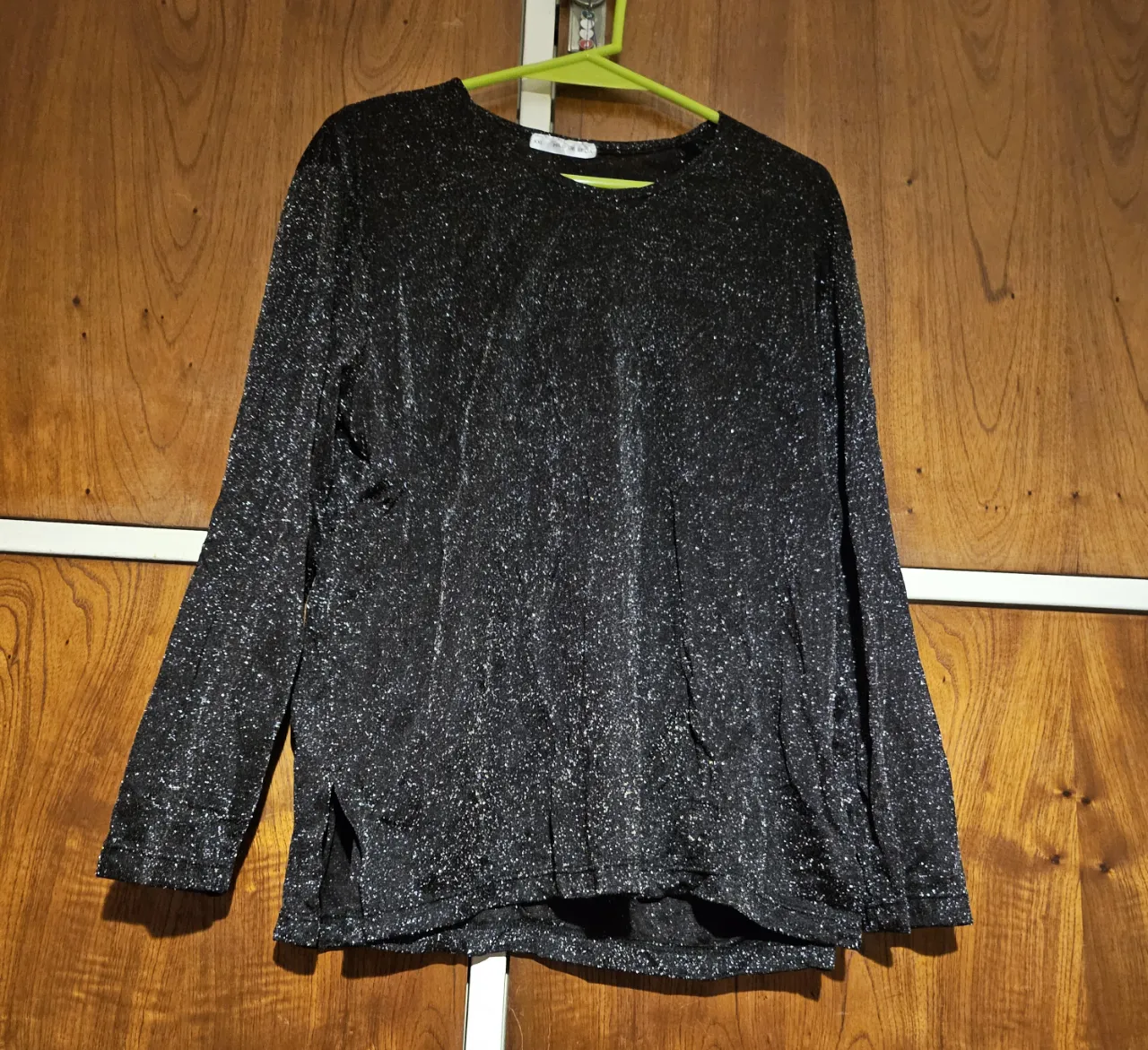 Remera de manga larga para mujer, de color negro con brillos plateados. Ideal para un look de fiesta o salida.