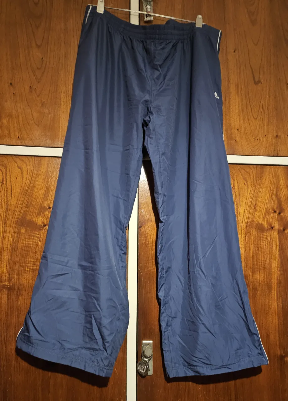 Pantalón deportivo suelto de color azul marino con detalles blancos en los laterales. Ideal para actividades deportivas o para un look casual y cómodo.