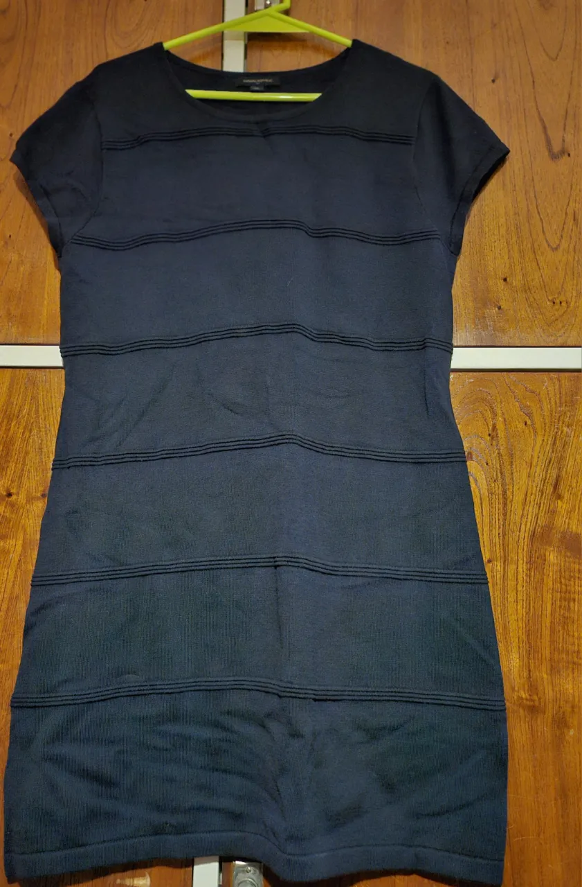 Vestido midi de punto, color azul marino, con detalles horizontales en relieve. Ideal para una salida casual o una ocasión especial.