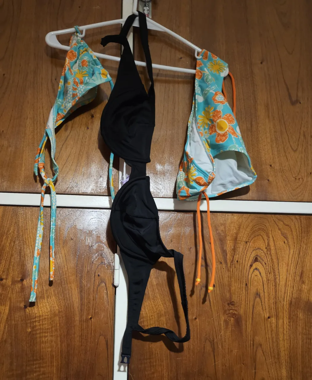 Conjunto de bikini con corpiño negro y bombacha con estampado floral en tonos turquesa y naranja. Ideal para la playa o pileta.