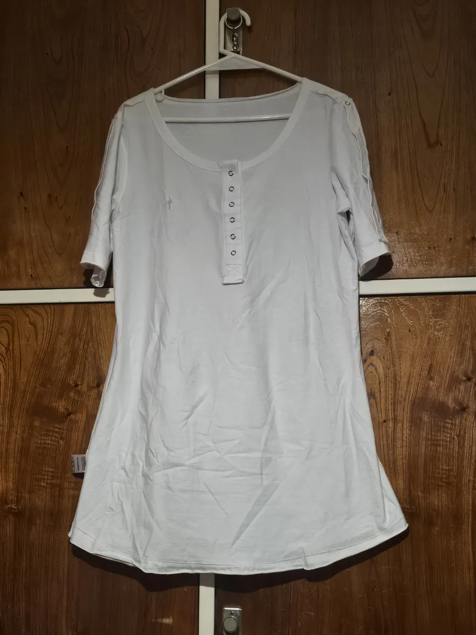 Blusa blanca de manga corta con botones en el frente y detalle en las mangas. Ideal para un look casual y fresco.