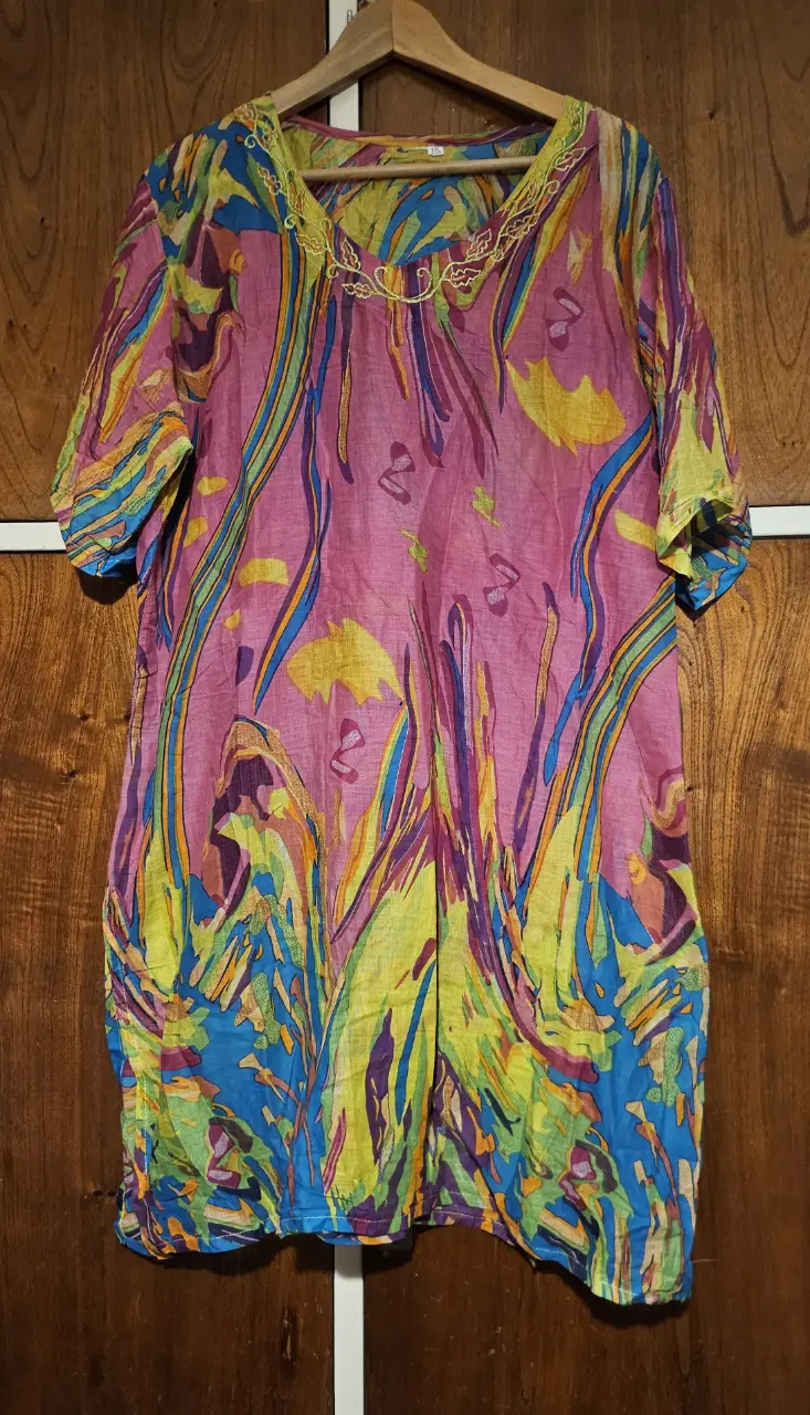 Blusa de mujer con estampado floral en tonos rosa, amarillo, azul y violeta. Cuello en V con detalles bordados. Ideal para un look bohemio y fresco.