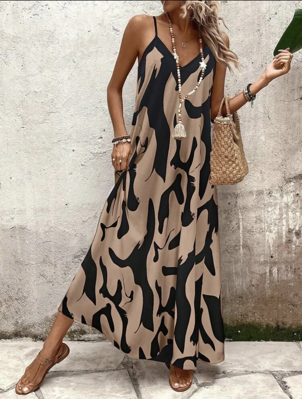 Vestido largo de mujer con estampado abstracto en tonos negro y crudo. Diseño con tirantes finos y corte fluido, ideal para un look bohemio y fresco.