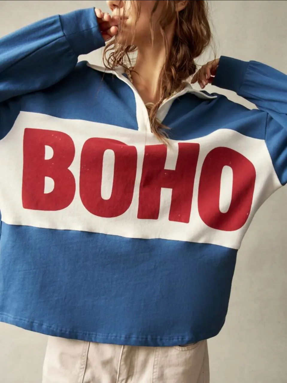 Buzo de cuello redondo con diseño "BOHO" en el frente. Estilo retro con mangas largas y cuello tipo polo. Ideal para un look casual y moderno.