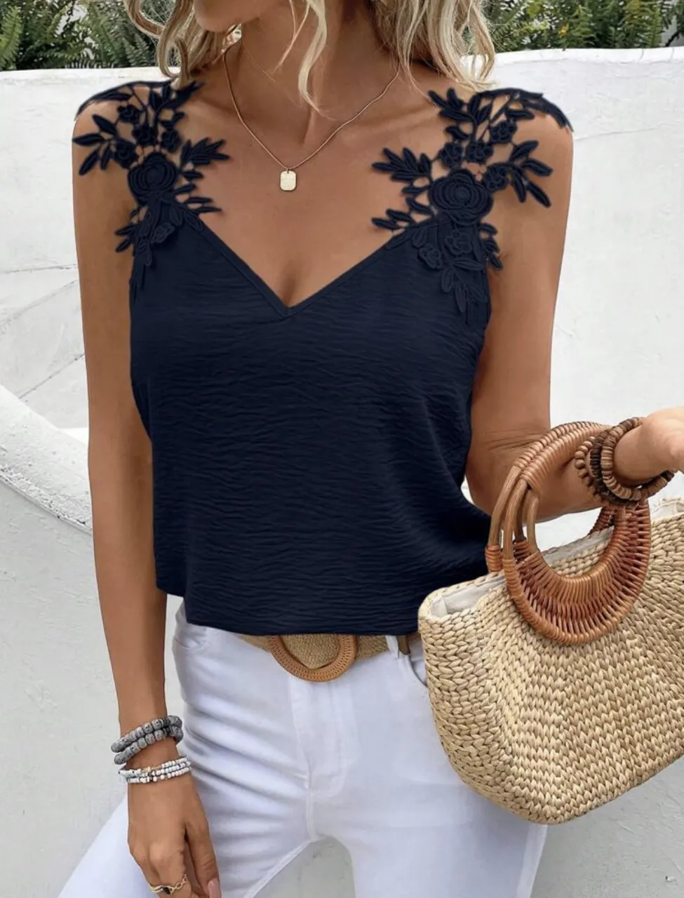 Top de mujer azul marino con detalles de encaje floral en los hombros. Cuello en V y diseño sin mangas, ideal para un look fresco y elegante.