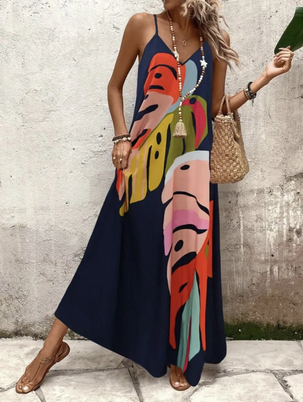 Vestido largo de mujer con estampado de hojas tropicales en tonos vibrantes. Diseño con tirantes finos y corte amplio, ideal para un look fresco y veraniego. Perfecto para combinar con sandalias y accesorios.